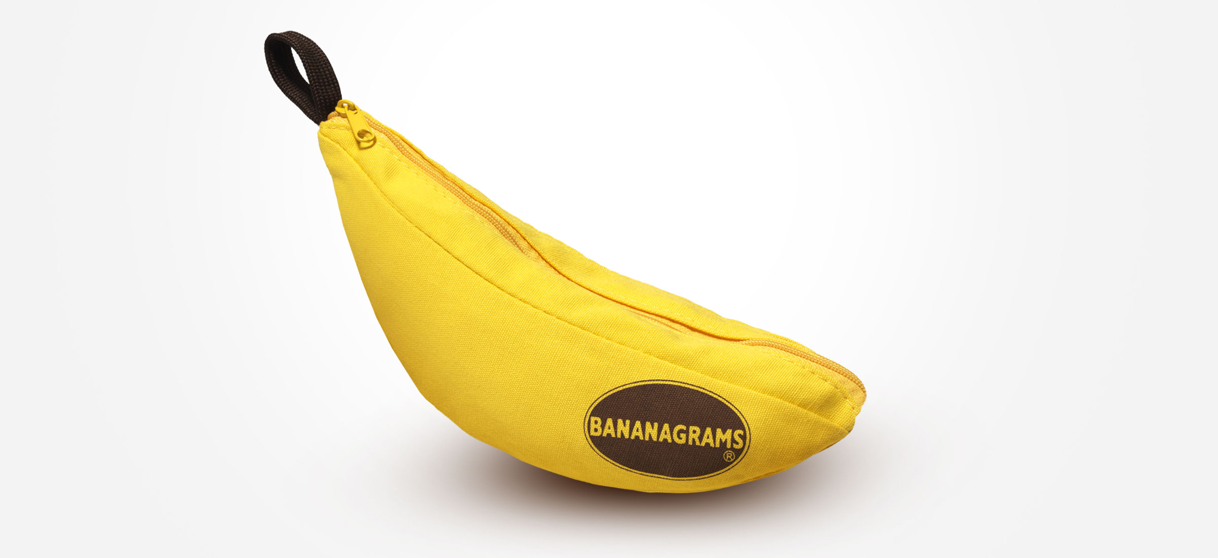 A banana shaped yellow cloth bag with a zipper at the top and the word Banagrams on it