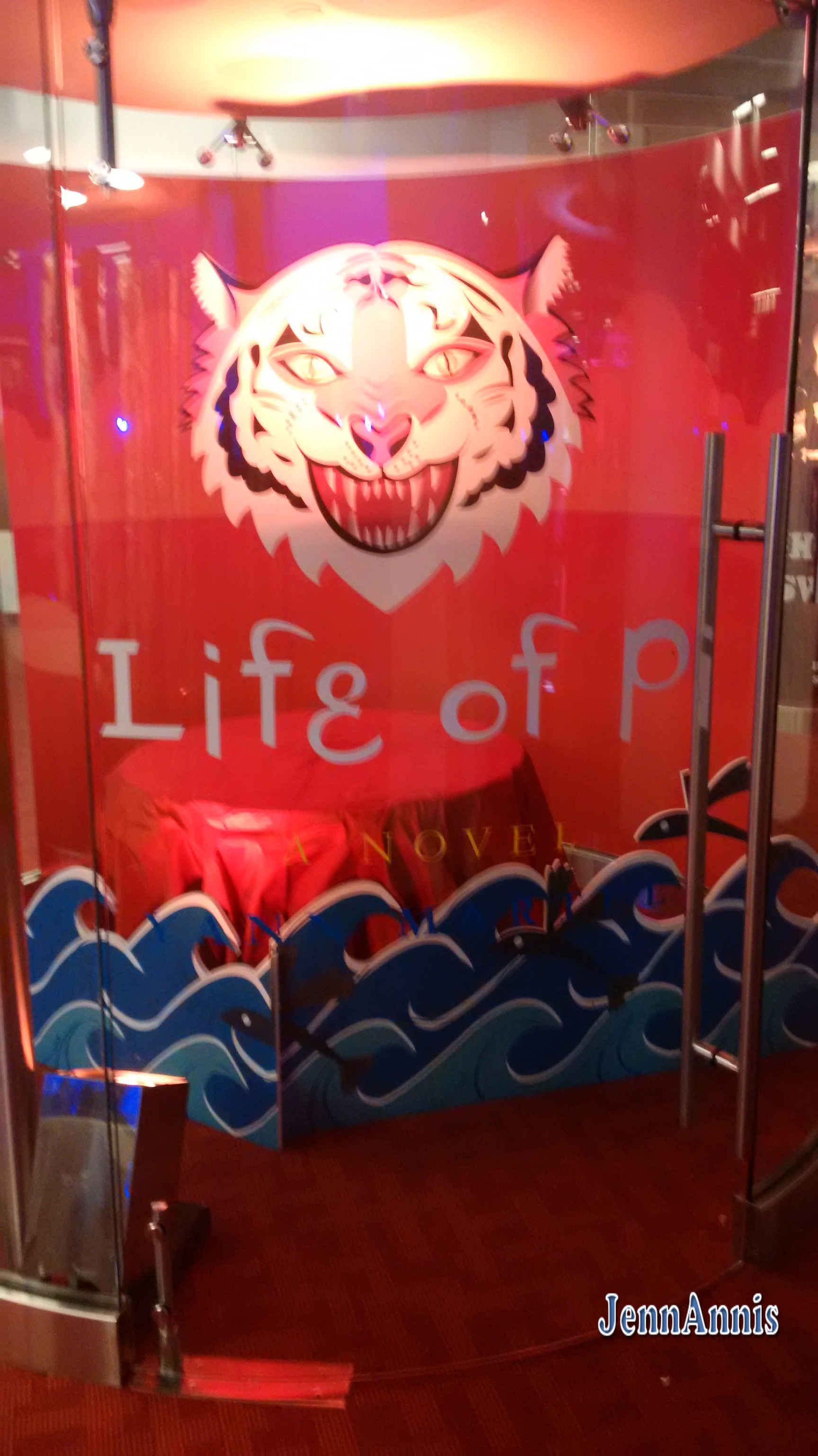 A tiger face over cardboard waves with the shadow of a boat Text reading: Life of Pi 