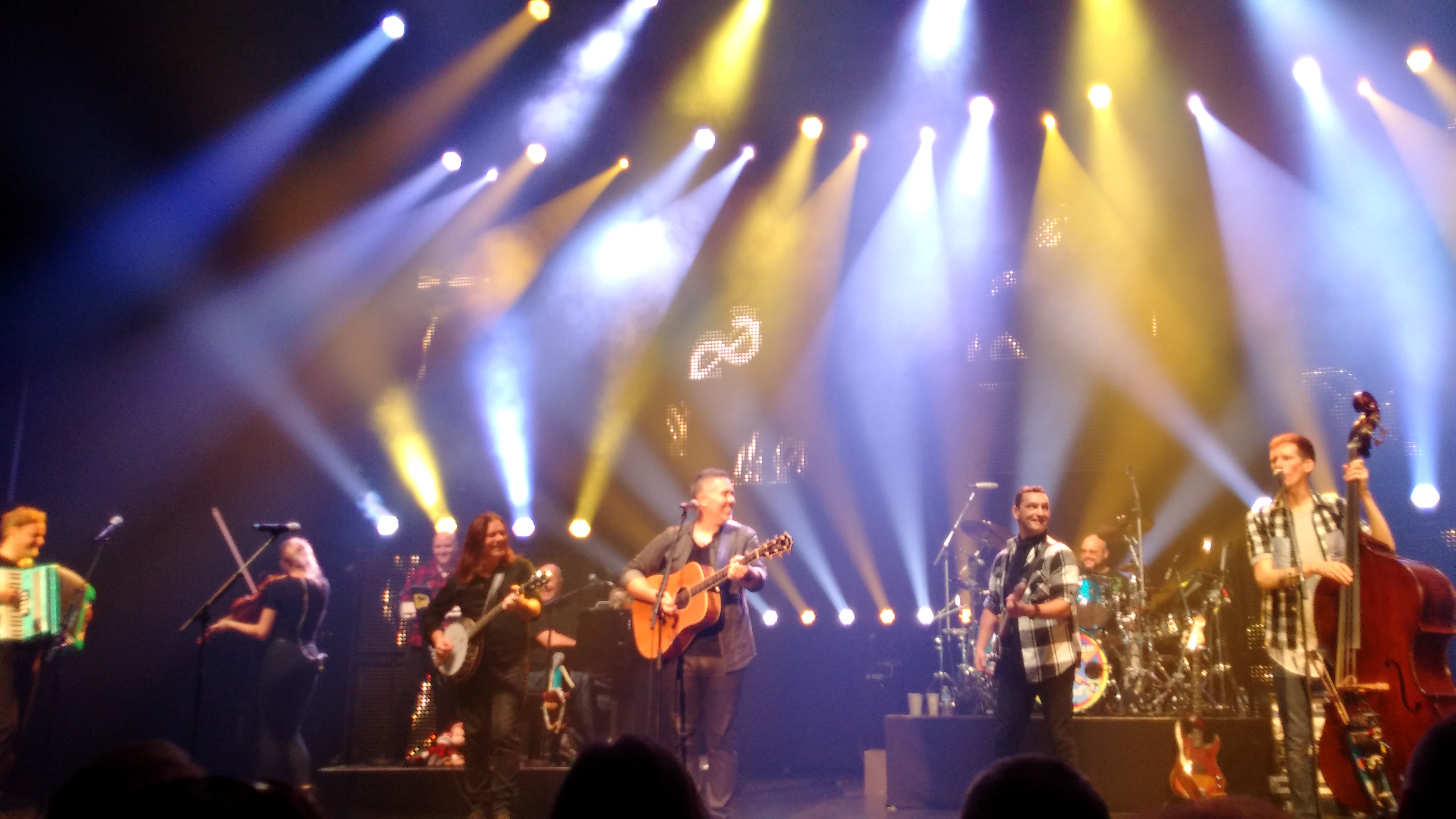 8 musicians on stage playing a variety of instruments