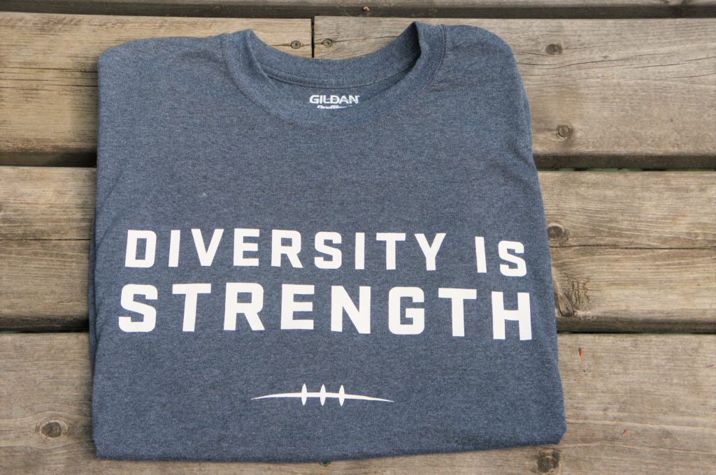 grey shirt with diversity is strength written on the front